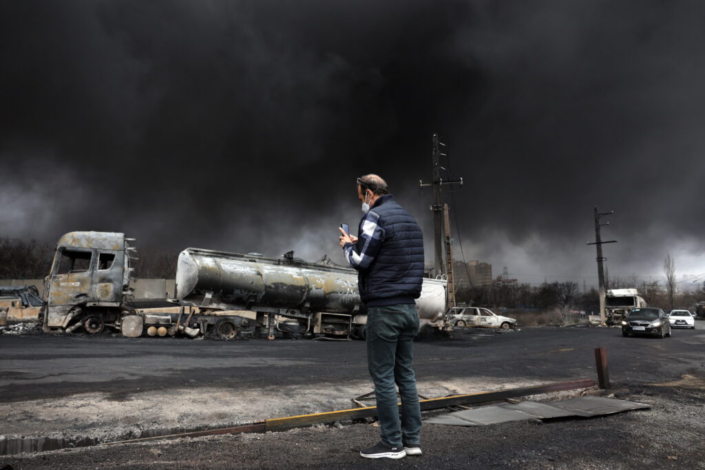An Iranian man looks as smoke still rises from Shahran Oil Refinery following last night airstrike in Tehran, Iran, 08 March 2026. A joint Israeli and US military operation continues to target multiple locations across Iran since the early hours of 28 February 2026.