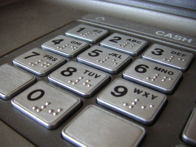 Close-up of the keypad on an ATM on the station platform.